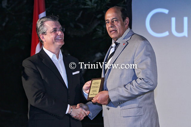 (R) Dr. Tim Goopeesingh accepts a congratulatory plaque from Mr. Robert Sowah