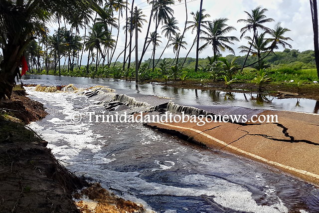 Flood waters drain into the collapsed section of the Manzanilla Road as a result of erosion of the sand base of the road