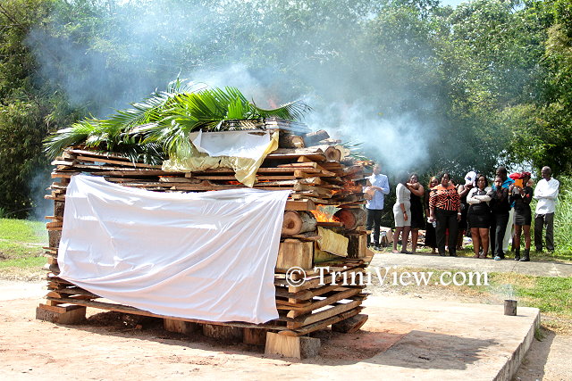 Family and friends watch the cremation of the body of Junior Noel